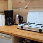 Keukentje met koelkast, koffie apparaat, waterkoker en gasstel